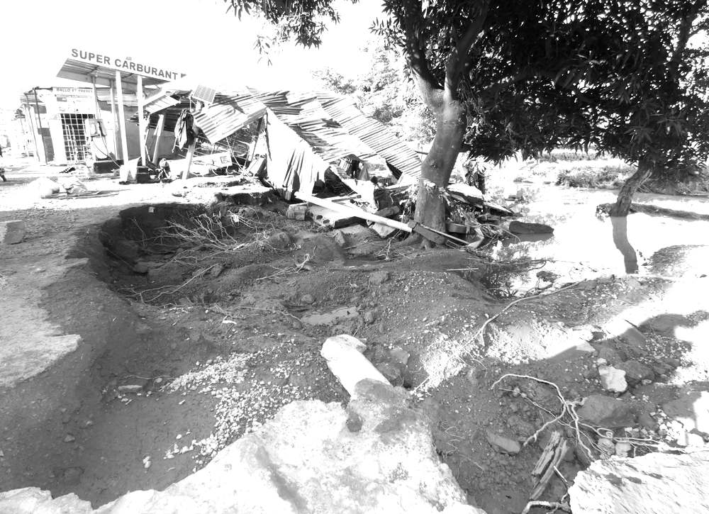 Près d'une station-service, un hangar de tôles effondré et un ravin creusé par les eaux de ruissellement après les fortes pluies à Sikasso