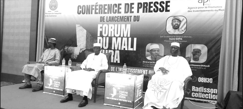 À la tribune, trois responsables prennent place devant l'affiche de la conférence de presse de lancement du Forum du Mali Kura, consacré à l'investissement