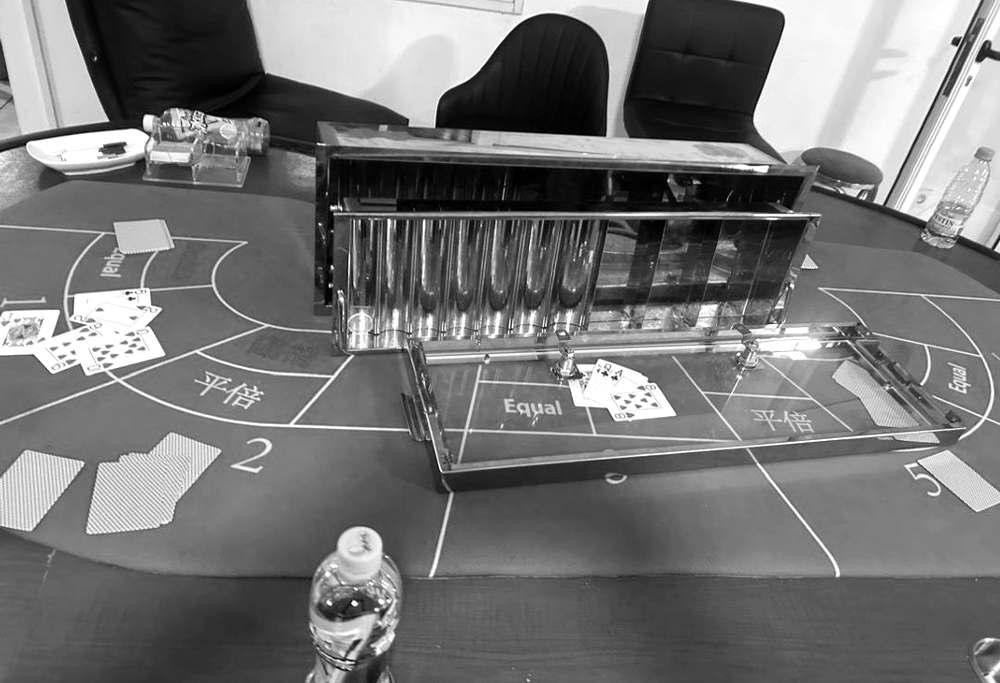 Une table de jeu de cartes aux inscriptions en chinois et en anglais, avec son présentoir à jetons métallique, dans la salle de jeu clandestine visée par l'affaire jugée à Bamako.